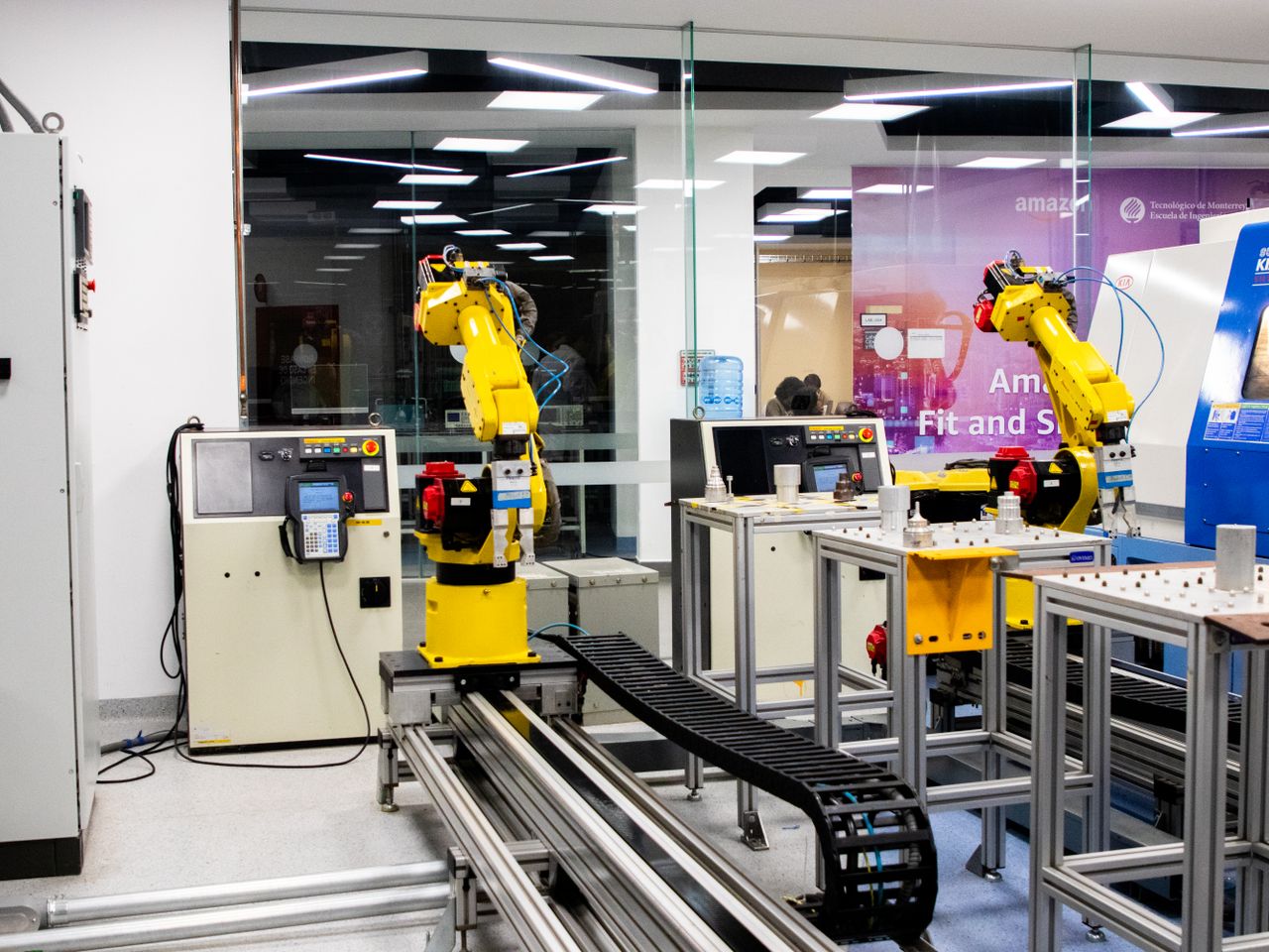 Services Robotic arms in action within a modern industrial control room setting, showcasing technology and production.